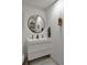 Modern bathroom with double sink vanity, round mirror, stylish fixtures, and decorative shelving at 1515 N Lakeshore Dr, Mount Pleasant, SC 29466
