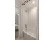 Clean and modern bathroom with white tile and a shower/bath combo, with view into bedroom at 1515 N Lakeshore Dr, Mount Pleasant, SC 29466