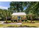 Beautiful single-story home with a metal roof and inviting porch, surrounded by mature palm trees and landscaping at 1515 N Lakeshore Dr, Mount Pleasant, SC 29466