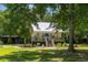 Charming single-story home with a metal roof, inviting porch, and lush, green yard with mature trees at 1515 N Lakeshore Dr, Mount Pleasant, SC 29466