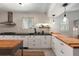 Modern kitchen showcasing white cabinets, stainless steel range hood, and breakfast bar at 1515 N Lakeshore Dr, Mount Pleasant, SC 29466