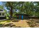 Well-maintained outbuilding with a blue door, surrounded by mature trees and lush greenery at 1515 N Lakeshore Dr, Mount Pleasant, SC 29466