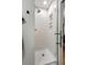 Modern tiled walk-in shower with glass door and shower niche, adjacent to bedroom at 1515 N Lakeshore Dr, Mount Pleasant, SC 29466