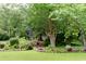 Lush front yard with decorative brick edging, flower beds, and shade trees creating a tranquil setting at 1551 Hutton Pl, Charleston, SC 29407