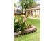 Beautiful landscaping around a lovely brick home with red shutters and mature trees at 1551 Hutton Pl, Charleston, SC 29407