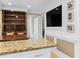 Open concept kitchen and living area with built in display shelving, TV, and granite countertop at 1551 Hutton Pl, Charleston, SC 29407
