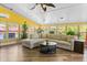 Bright sunroom with a large sectional sofa, hardwood floors, and many windows at 1551 Hutton Pl, Charleston, SC 29407