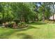 Expansive backyard with lush green lawn, mature trees, and manicured flower beds for outdoor enjoyment at 1551 Hutton Pl, Charleston, SC 29407