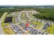 Aerial view of a Primary-planned community with mature trees, serene pond, and a pin on one of the houses at 1963 Longhorn Ln, Summerville, SC 29485