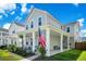 Charming two-story home featuring a welcoming front porch with classic columns and an American flag at 1963 Longhorn Ln, Summerville, SC 29485