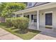 Inviting front porch features a rocking chair, neat landscaping and front door with sidelight at 2136 Kings Gate Ln, Mount Pleasant, SC 29466