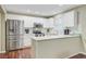 Bright kitchen features stainless steel appliances, white cabinets, and a breakfast bar with stylish wood floors at 2136 Kings Gate Ln, Mount Pleasant, SC 29466