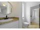 Half bathroom featuring granite countertop and round decorative mirror at 2258 Arthur Gaillard Ln, Charleston, SC 29414