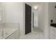 Bright bathroom with marble countertop, soaking tub and black door at 2258 Arthur Gaillard Ln, Charleston, SC 29414