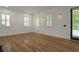 Sunlit living space with hardwood floors, wall sconces, and a series of shuttered windows, offering an open, airy feel at 2258 Arthur Gaillard Ln, Charleston, SC 29414