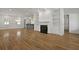 Open-concept living room featuring hardwood floors, a fireplace with built-in shelves, and a view into the kitchen at 2258 Arthur Gaillard Ln, Charleston, SC 29414