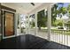 Relaxing screened porch with black wood floors, white pillars, and views of the lush yard at 2258 Arthur Gaillard Ln, Charleston, SC 29414