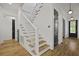 Open staircase with wooden stairs, white risers and white wood railing at 2258 Arthur Gaillard Ln, Charleston, SC 29414