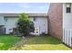 Backyard featuring a grassy lawn, exterior siding, brick and a tree providing shade at 2362 Parsonage Rd # 2H, Charleston, SC 29414