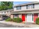 Inviting townhouse with a red door, blending brick and siding, complemented by lush greenery for a welcoming appeal at 2362 Parsonage Rd # 2H, Charleston, SC 29414