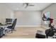 Bright bonus room with sleek ceiling fan, wood floors, neutral paint, Peloton, desk and gaming chair at 240 Lucca Dr, Summerville, SC 29486
