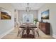 Staged dining room with area rug, artwork, modern chandelier, dining table and six chairs at 240 Lucca Dr, Summerville, SC 29486