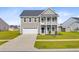 Charming two-story home featuring a second-story balcony, attached garage, and well-maintained lawn at 240 Lucca Dr, Summerville, SC 29486