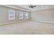 Large main bedroom with plush carpeting, tray ceiling, fan, and three bright windows at 240 Lucca Dr, Summerville, SC 29486