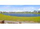 Scenic view of pond surrounded by green grass, bordering a community of homes at 240 Lucca Dr, Summerville, SC 29486