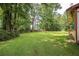 Expansive backyard with lush green grass and mature trees, ideal for outdoor activities at 2425 Vistavia Rd, North Charleston, SC 29406