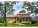 Back exterior of home with green lawn, mature trees, screened porch and brick/siding architecture at 2425 Vistavia Rd, North Charleston, SC 29406