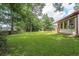 Spacious backyard featuring a well-maintained lawn, mature trees, and partial view of the home at 2425 Vistavia Rd, North Charleston, SC 29406