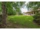 Large grassy backyard with mature trees shading the home, offering a serene outdoor space at 2425 Vistavia Rd, North Charleston, SC 29406