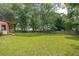 Large, green backyard with wooden fence and mature trees offering plenty of space for outdoor activities at 2425 Vistavia Rd, North Charleston, SC 29406