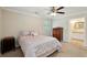 Cozy bedroom with neutral walls, a ceiling fan, and a doorway leading to a bathroom at 2425 Vistavia Rd, North Charleston, SC 29406