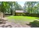 Lush backyard featuring green grass, privacy fence, mature trees providing shade, and a cozy entertainment space at 2831 Chicopee Dr, North Charleston, SC 29420