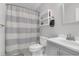 This bathroom features a gray vanity, toilet, shower with striped curtain, and a shelf at 2831 Chicopee Dr, North Charleston, SC 29420
