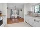 Open kitchen and dining area features white cabinets, stainless steel sink, and hardwood floors at 2831 Chicopee Dr, North Charleston, SC 29420