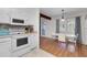 Bright kitchen and dining area features white appliances, hardwood floors, and natural light at 2831 Chicopee Dr, North Charleston, SC 29420