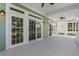 A rear covered porch featuring multiple doors, light fixtures, and ceiling fans at 3095 S Shore Dr, Charleston, SC 29407