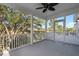 Inviting screened-in porch with views of mature trees, ceiling fan, and access to outdoors at 3095 S Shore Dr, Charleston, SC 29407