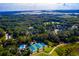 Aerial view featuring tennis courts and a pool surrounded by lush greenery and waterfront, capturing recreational beauty at 3221 Johnstowne St, Johns Island, SC 29455