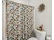 Bathroom with a floral shower curtain, a toilet with decor, and a woven basket hanging on the wall at 3221 Johnstowne St, Johns Island, SC 29455