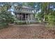 Two-story home with a screened porch, white railing, and steps down to a leafy yard at 3221 Johnstowne St, Johns Island, SC 29455