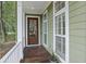 Inviting front door with sidelights and wood floors on a charming porch at 3221 Johnstowne St, Johns Island, SC 29455