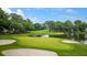 Scenic golf course view featuring a green with a flag, a pond, sand traps, and lush green grass at 3221 Johnstowne St, Johns Island, SC 29455