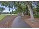 Winding path surrounded by tall trees on a manicured landscape with a golf course in the background at 3221 Johnstowne St, Johns Island, SC 29455