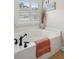 Bright bathroom boasts a soaking tub beneath a shuttered window and updated bronze fixtures at 3616 Bagley Dr, Mount Pleasant, SC 29466