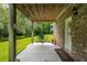 Relaxing covered patio with brick siding, lush greenery and seating area overlooking the grassy lawn and pond at 3616 Bagley Dr, Mount Pleasant, SC 29466