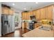 A bright kitchen features stainless appliances, wood floors, tan cabinets, and a door leading to a patio at 3616 Bagley Dr, Mount Pleasant, SC 29466